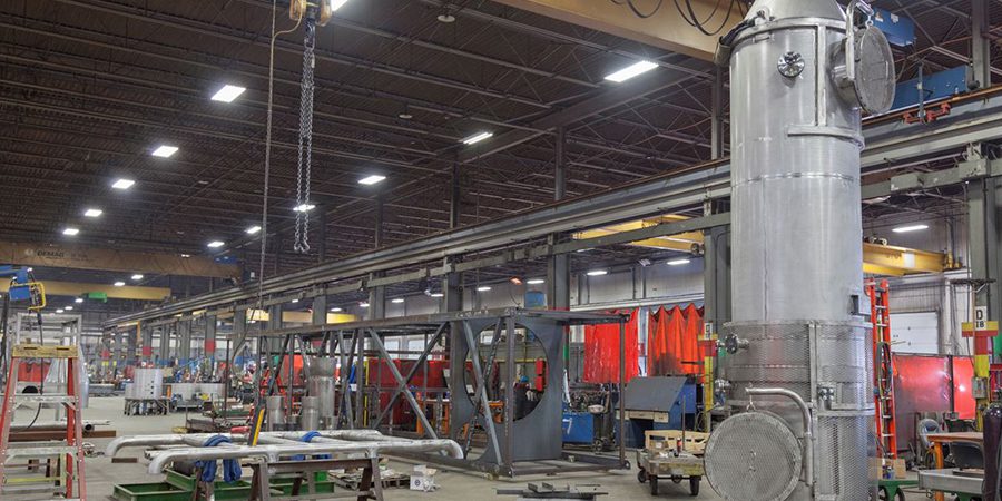 large fabrication shop showing chains from overhead crane